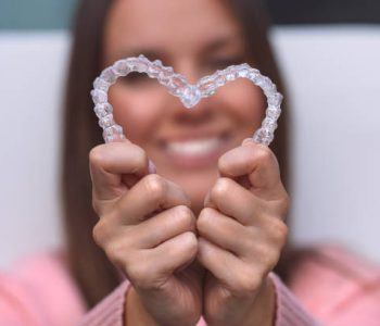 Woman with perfect smile after invisible invisalign aligners treatment. High quality photo